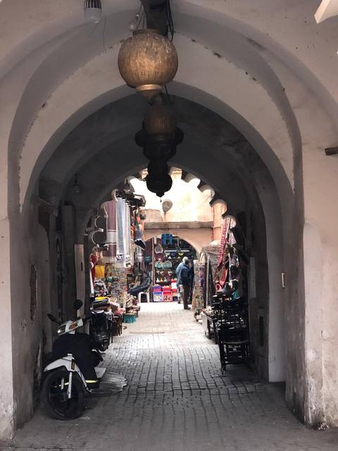 Des lanternes en laiton suspendues sous une arche des souks
